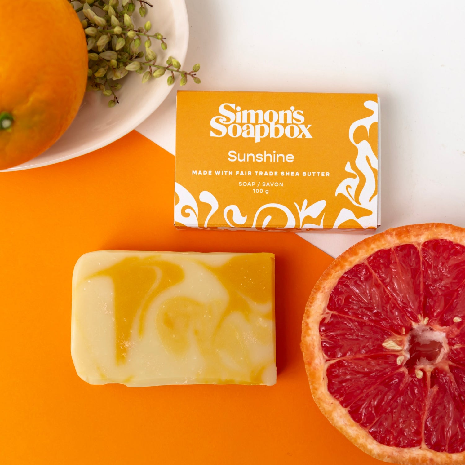 two bars of soap, one in a black and white package and one unwrapped with a black and grey swirl