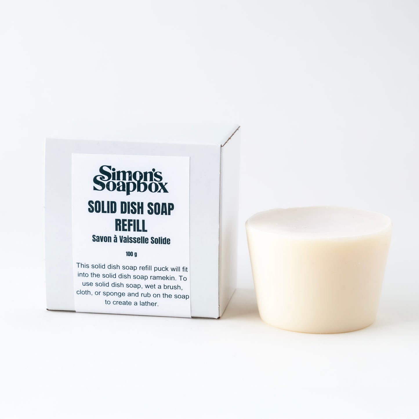 white soap puck sits beside packaging