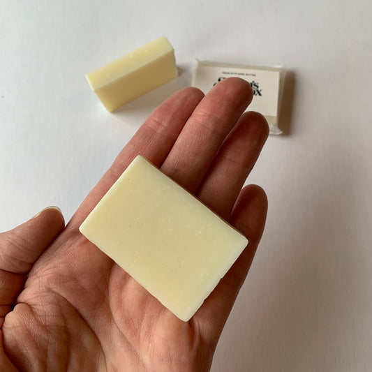 mini bar of soap unwrapped on hand