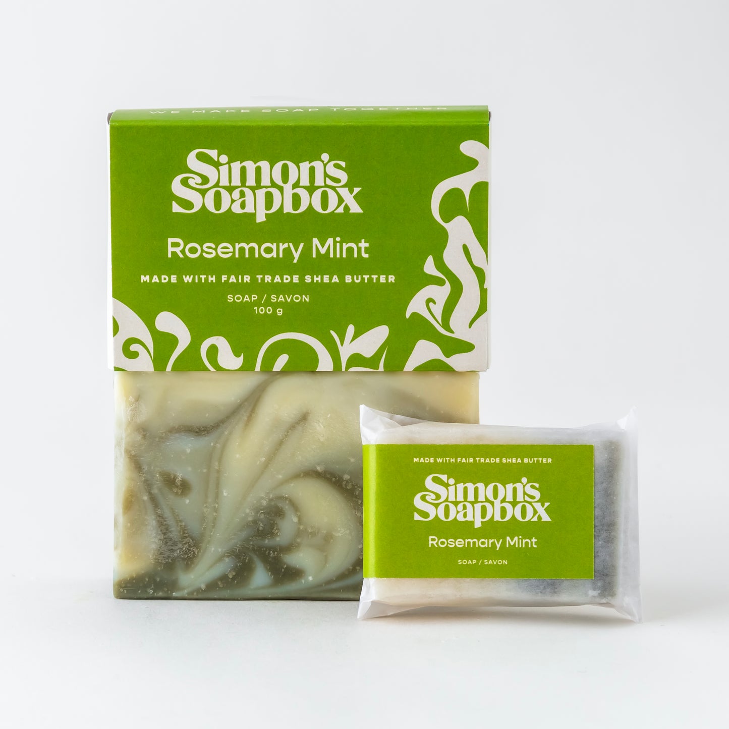 packaged and unpackaged full size bars of soap with mini bar in foreground