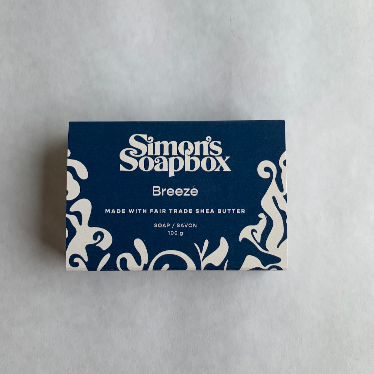blue package of soap with swirl design and words Simons Soapbox Breeze, made with fair trade shea butter 100 g
