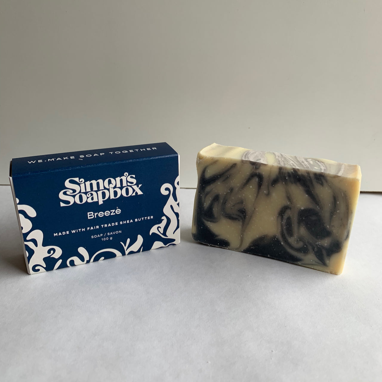two bars of soap, one with blue swirls, one in a blue box