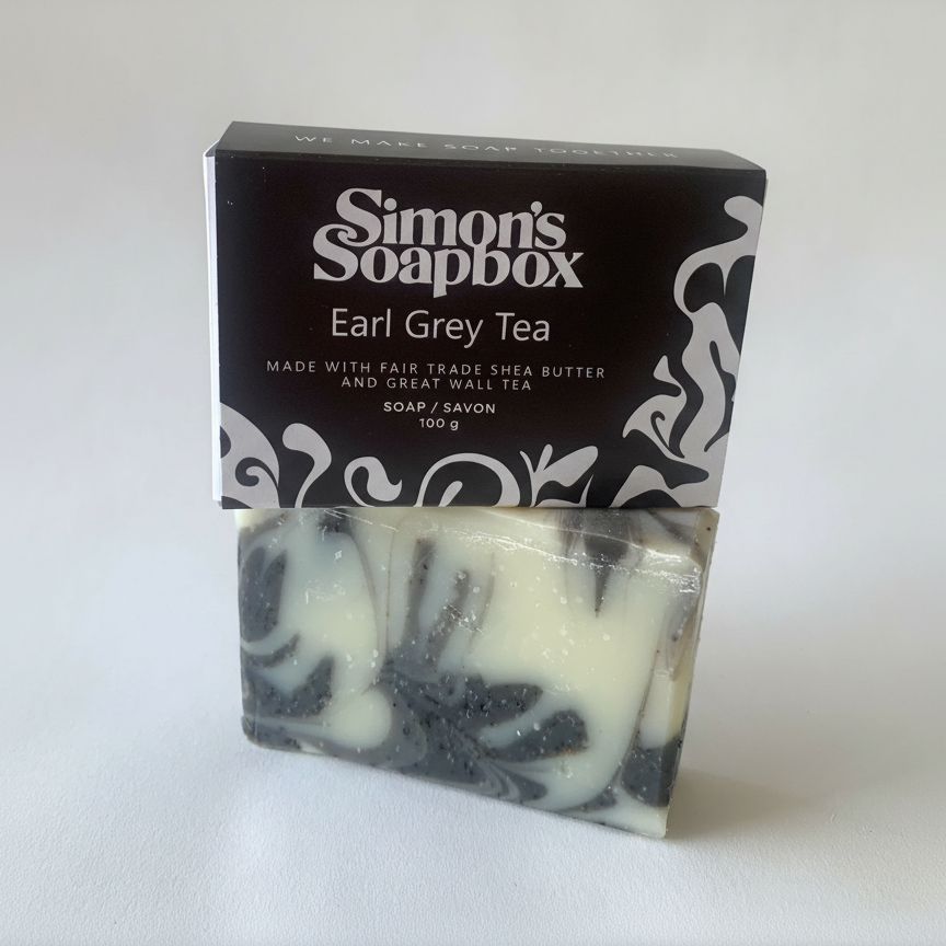 Bar of soap with black and white design in front of a 'Simon's Soapbox' packaging on a white background