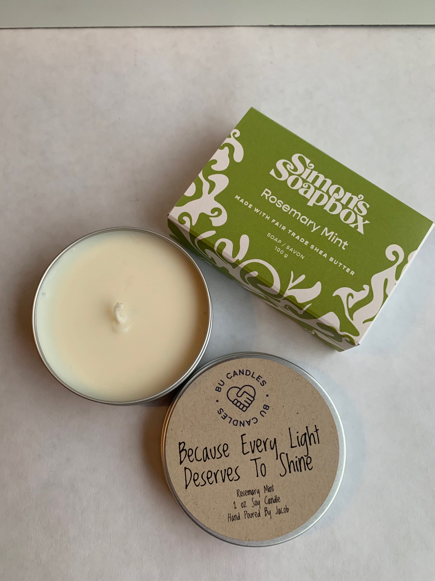 green package of soap and candle with lid beside it