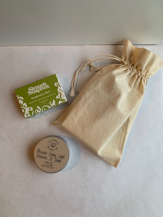 green bar of soap with small tin beside a cream colour cotton drawstring bag
