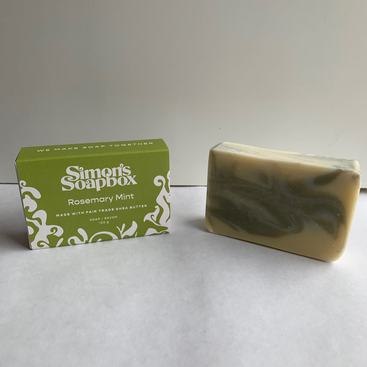 two bars of soap, one in a package and one unwrapped with a pale green swirl