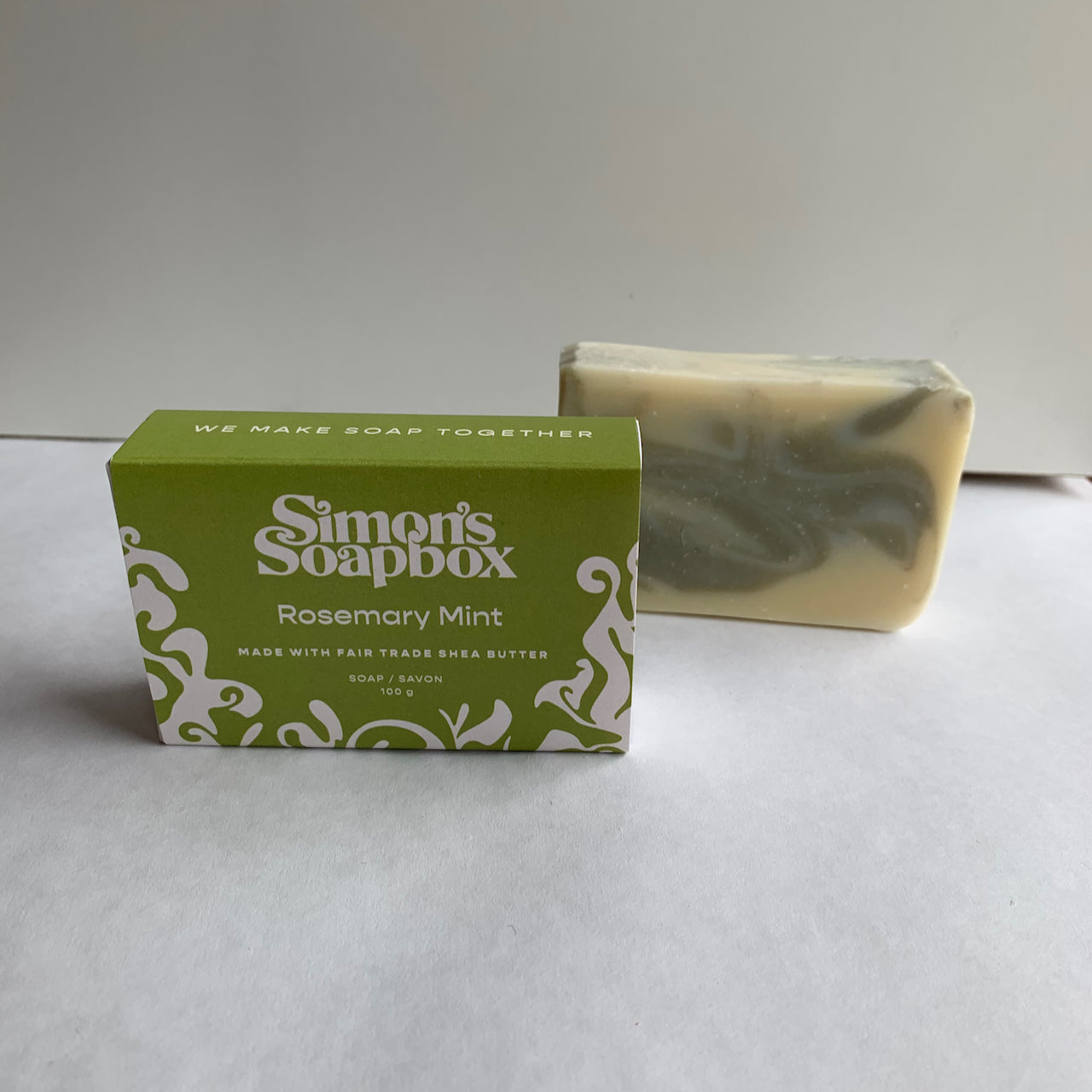 two bars of soap, one in a package that has the words we make soap together on the side