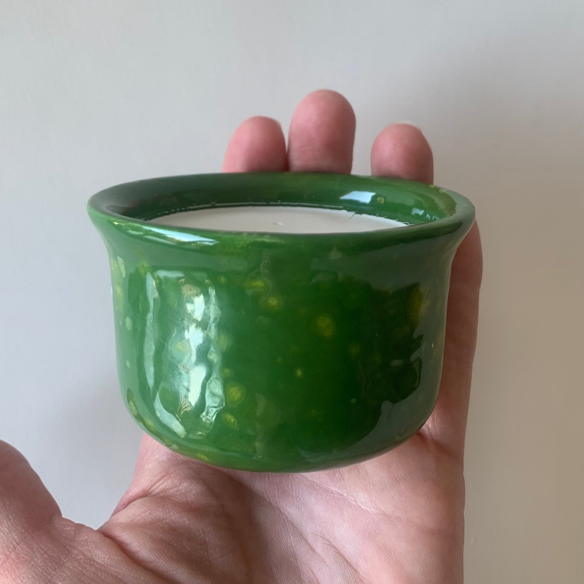side view of green ramekin with small yellow fleck